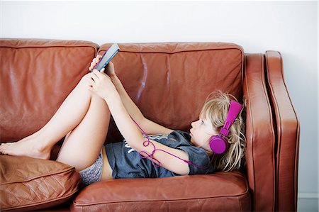 simsearch:6102-08168912,k - Girl on sofa using digital tablet Photographie de stock - Premium Libres de Droits, Code: 6102-08881784