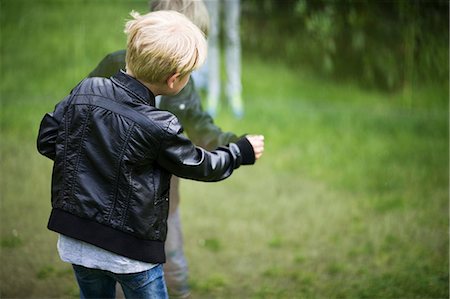 Boy looking at his reflection on glass surface Stock Photo - Premium Royalty-Free, Code: 6102-08881840