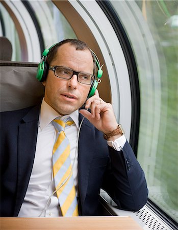 simsearch:6102-07455789,k - Businessman listening to music on high speed train Stock Photo - Premium Royalty-Free, Code: 6102-08800203