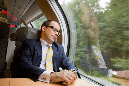 Businessman having nap on high speed train Stock Photo - Premium Royalty-Free, Code: 6102-08800205