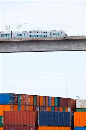 Monorail on elevated bridge over cargo containers Stock Photo - Premium Royalty-Free, Code: 6102-08800436