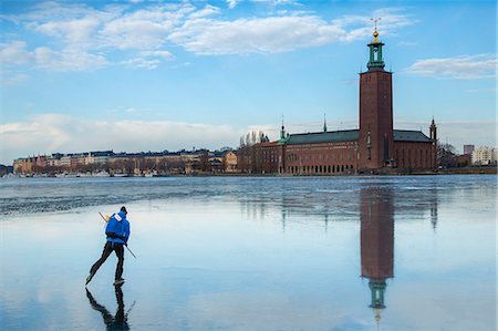 simsearch:6102-08520961,k - Person ice skating on sea, Stockholm City Hall on background, Sweden Stock Photo - Premium Royalty-Free, Code: 6102-08951711
