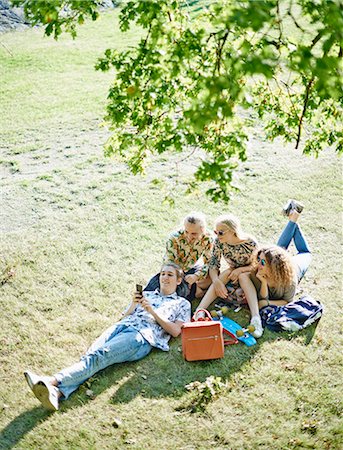 simsearch:6102-08542382,k - Happy friends relaxing on lawn Stock Photo - Premium Royalty-Free, Code: 6102-08951803