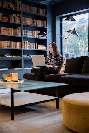 sweden window lamp - Woman sitting on the couch and working at laptop Stock Photo - Premium Royalty-Free, Code: 6102-08951837