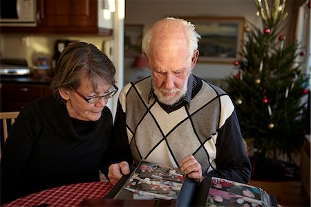 senior couple photo album - Old couple looking at photos Stock Photo - Premium Royalty-Free, Code: 6102-08951945