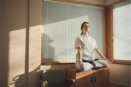 Female doctor meditating by window Stock Photo - Premium Royalty-Free, Code: 6102-08952046