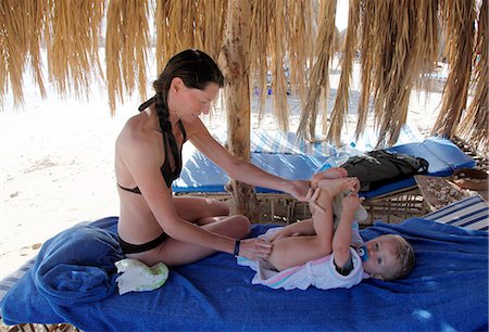 photo adult diaper family - Mother changing sons diaper on beach Stock Photo - Premium Royalty-Free, Code: 6102-08995119