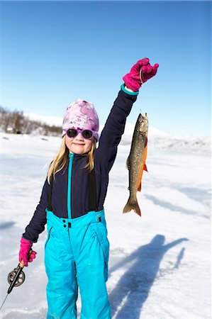 Happy girl holding fish Stock Photo - Premium Royalty-Free, Code: 6102-08995535