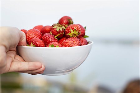 simsearch:6102-07157973,k - Hand with bowl of strawberries Stock Photo - Premium Royalty-Free, Code: 6102-08995603