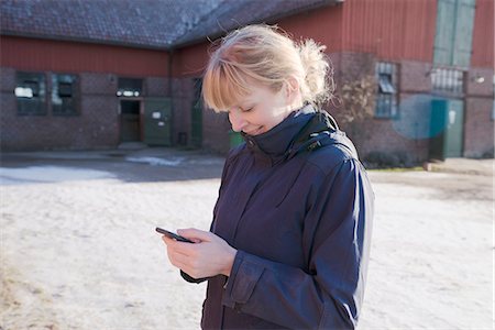 farm phone - Woman using cell phone on farm yard Stock Photo - Premium Royalty-Free, Code: 6102-08996317