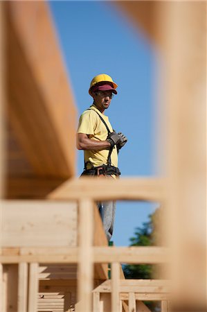 framing roof rafters - Carpenter standing on roof frame Stock Photo - Premium Royalty-Free, Code: 6105-05396061