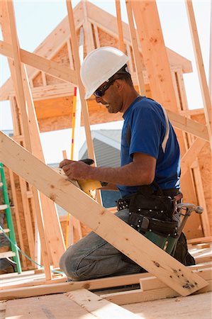 Carpenter measuring a wooden beam Stock Photo - Premium Royalty-Free, Code: 6105-05396090