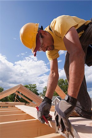 Carpenter marking spacing of rafters with a pencil Stock Photo - Premium Royalty-Free, Code: 6105-05396034