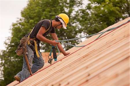 framing roof rafters - Carpenter using safety strap on the roof of a house under construction Stock Photo - Premium Royalty-Free, Code: 6105-05396146