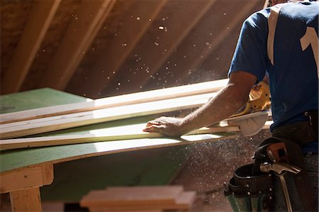 sawing - Hispanic carpenter using circular saw on trim strip at a house under construction Stock Photo - Premium Royalty-Free, Code: 6105-05396188