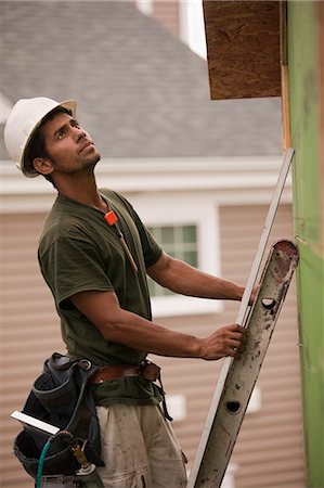 Hispanic carpenter on a ladder with a level at a house under construction Stock Photo - Premium Royalty-Free, Code: 6105-05396125