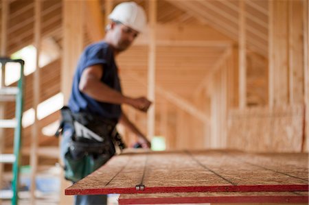 Hispanic carpenter snapping a string line on a roof panel at a house under construction Stock Photo - Premium Royalty-Free, Code: 6105-05396278