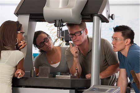 Engineering professor demonstrating a coordinate measuring machine to students Stock Photo - Premium Royalty-Free, Code: 6105-05396349