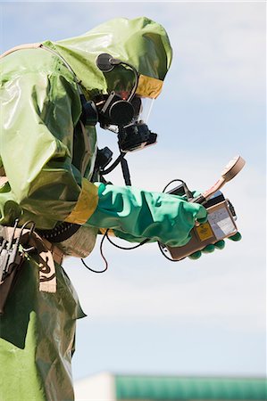 radiating (glowing or emitting light or heat) - HazMat firefighter taking radiation reading Stock Photo - Premium Royalty-Free, Code: 6105-05396496