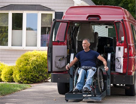 Man with spinal cord injury in a wheelchair getting in his accessible van Stock Photo - Premium Royalty-Free, Code: 6105-05396584