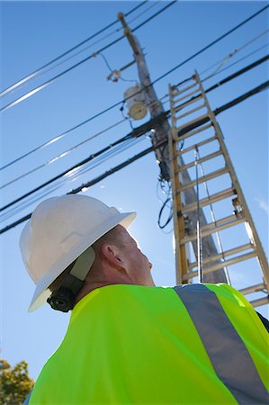 simsearch:6105-05953745,k - Engineer placing a ladder to climb power pole Stock Photo - Premium Royalty-Free, Code: 6105-05396601
