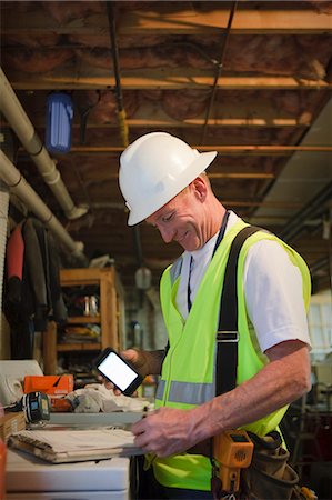 simsearch:6105-05953745,k - Cable installer working in the cellar of a house completing a work order form Stock Photo - Premium Royalty-Free, Code: 6105-05396605