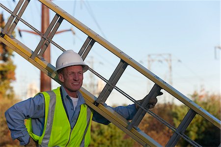 simsearch:6105-05953745,k - Engineer holding ladder to install equipment on power poles Stock Photo - Premium Royalty-Free, Code: 6105-05396629