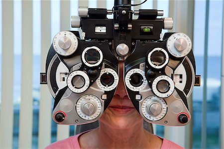 phorometer - Woman getting eye exam with a phoropter Stock Photo - Premium Royalty-Free, Code: 6105-05396633