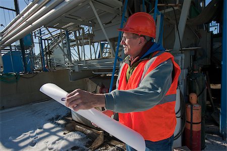 Engineer holding a blueprint at industrial plant Stock Photo - Premium Royalty-Free, Code: 6105-05396870