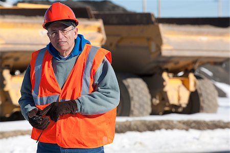 dump truck - Engineer using a walkie-talkie in earth mover truck yard Stock Photo - Premium Royalty-Free, Code: 6105-05396879