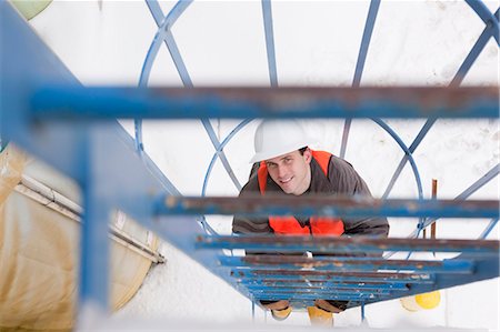 survey - Engineer climbing a tower with safety enclosure Stock Photo - Premium Royalty-Free, Code: 6105-05396963