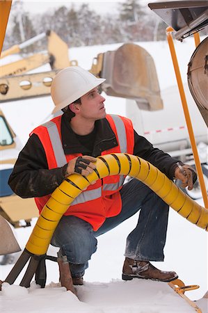 Engineer inspecting an earth mover Stock Photo - Premium Royalty-Free, Code: 6105-05396994