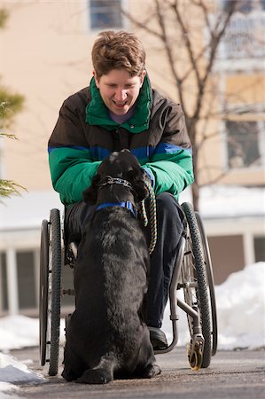 smiling lab dog - Woman with multiple sclerosis playing with a service dog in winter Stock Photo - Premium Royalty-Free, Code: 6105-05397006