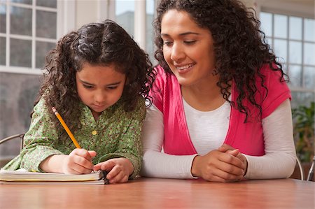 simsearch:695-03374346,k - Hispanic woman assisting her daughter while doing homework Stock Photo - Premium Royalty-Free, Code: 6105-05397186