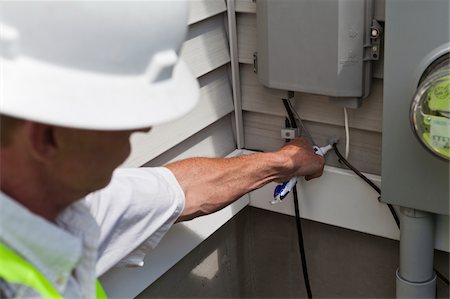 simsearch:6105-05953745,k - Cable installer applying weather proof sealant to the cable installation Stock Photo - Premium Royalty-Free, Code: 6105-05953746