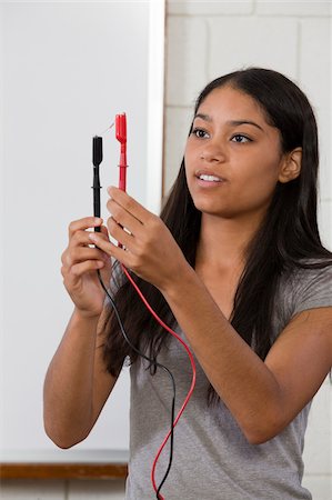 Engineering student connecting resistor using alligator clips Stock Photo - Premium Royalty-Free, Code: 6105-05953748