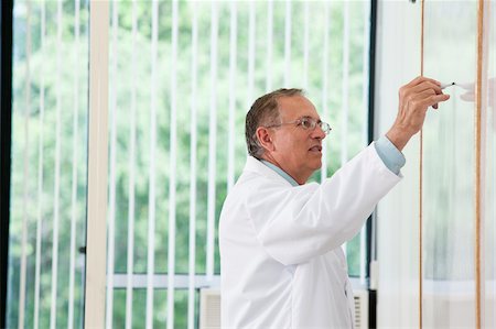 Professor at whiteboard during lecture Stock Photo - Premium Royalty-Free, Code: 6105-05953705