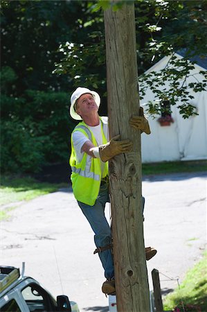 simsearch:6105-05953745,k - Lineman climbing a pole for installation Stock Photo - Premium Royalty-Free, Code: 6105-05953738