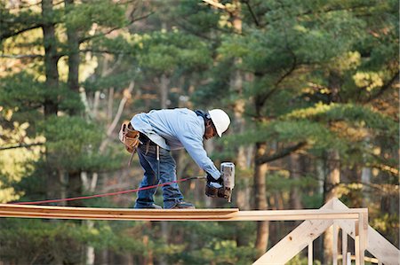 power tool work man - Carpenter using a nail gun on a temporary platform Stock Photo - Premium Royalty-Free, Code: 6105-06042988