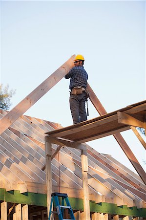 framing roof rafters - Carpenter placing a rafter Stock Photo - Premium Royalty-Free, Code: 6105-06042990