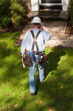 simsearch:6105-05953745,k - Cable installer on cell phone preparing to enter home for installation Stock Photo - Premium Royalty-Free, Code: 6105-06042935