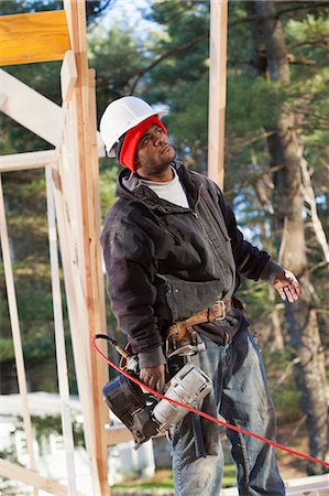 simsearch:693-06016727,k - Carpenter with a nail gun reviewing work Stock Photo - Premium Royalty-Free, Code: 6105-06043046