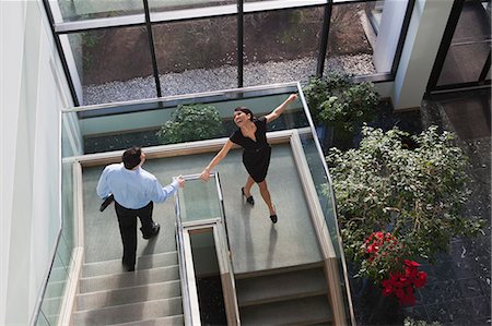 steps high angle - Business couple joyfully walking down stairs of office building Stock Photo - Premium Royalty-Free, Code: 6105-06043087