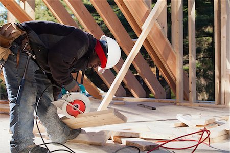 Carpenter cutting bevel on rafter with a circular saw Stock Photo - Premium Royalty-Free, Code: 6105-06043031