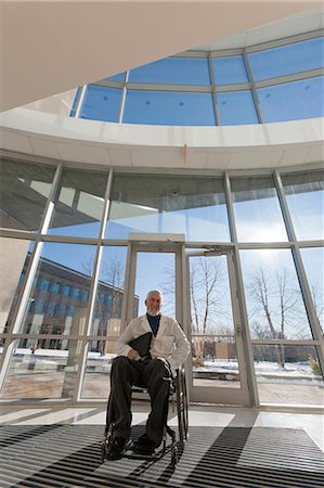 disable - Doctor with muscular dystrophy in wheelchair at hospital entrance Stock Photo - Premium Royalty-Free, Code: 6105-06043131