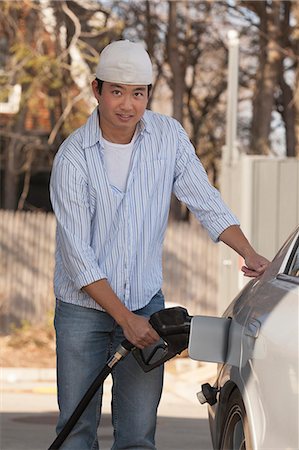 Chinese man refuelling his car at the gas station Stock Photo - Premium Royalty-Free, Code: 6105-06702871