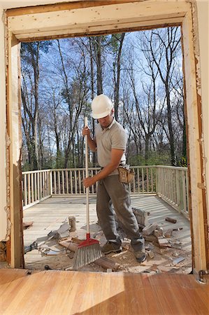 Hispanic carpenter cleaning newly cut door entrance from house to deck Stock Photo - Premium Royalty-Free, Code: 6105-06702960