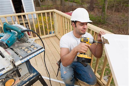 simsearch:6105-05953745,k - Hispanic carpenter installing hinges on new door before installation Stock Photo - Premium Royalty-Free, Code: 6105-06702965