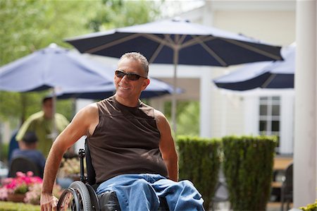 Man with spinal cord injury in a wheelchair sitting at a cafe Foto de stock - Sin royalties Premium, Código: 6105-06703052