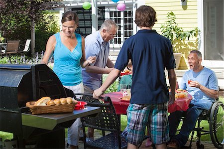 Man with spinal cord injury in wheelchair at family picnic Stock Photo - Premium Royalty-Free, Code: 6105-06703004